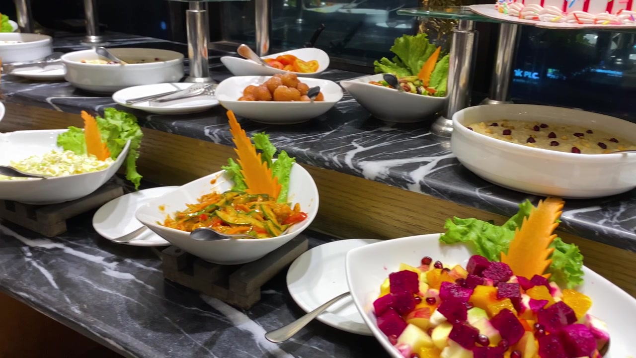 Ciotole di insalata fresca e frutta, antipasto esposto al bancone del buffet dell'hotel - ripresa panoramica