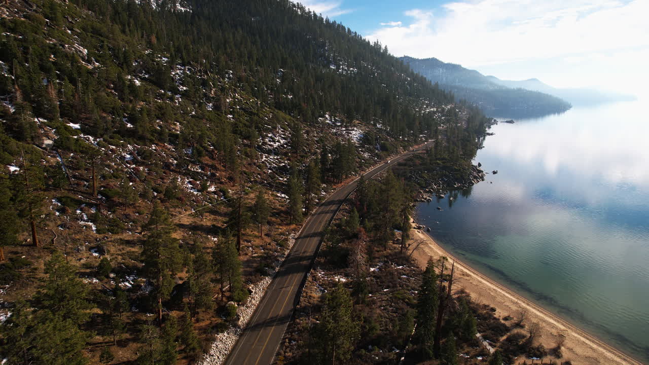 Ripresa con drone di strada costiera, foresta e spiaggia sul Lago Tahoe USA in una giornata invernale di sole