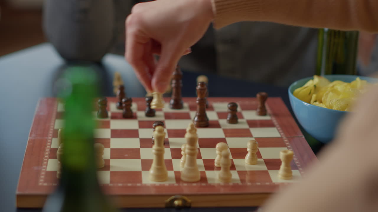 People playing chess board games on wooden table at home