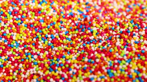 fingers interacting with vibrant candy sprinkles