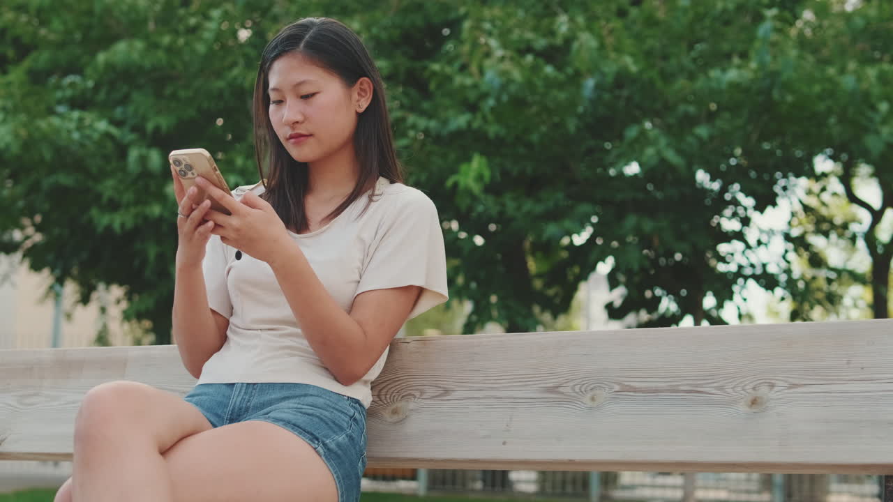 Woman using phone on park bench