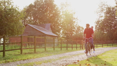 Zeitlupenaufnahme-Eines-Romantischen-Paares,-Das-Bei-Sonnenuntergang-Fahrrad-Entlang-Der-Landstraße-Fährt