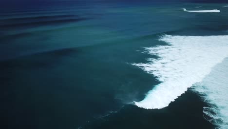 vista aérea de las olas del océano chocando contra la orilla