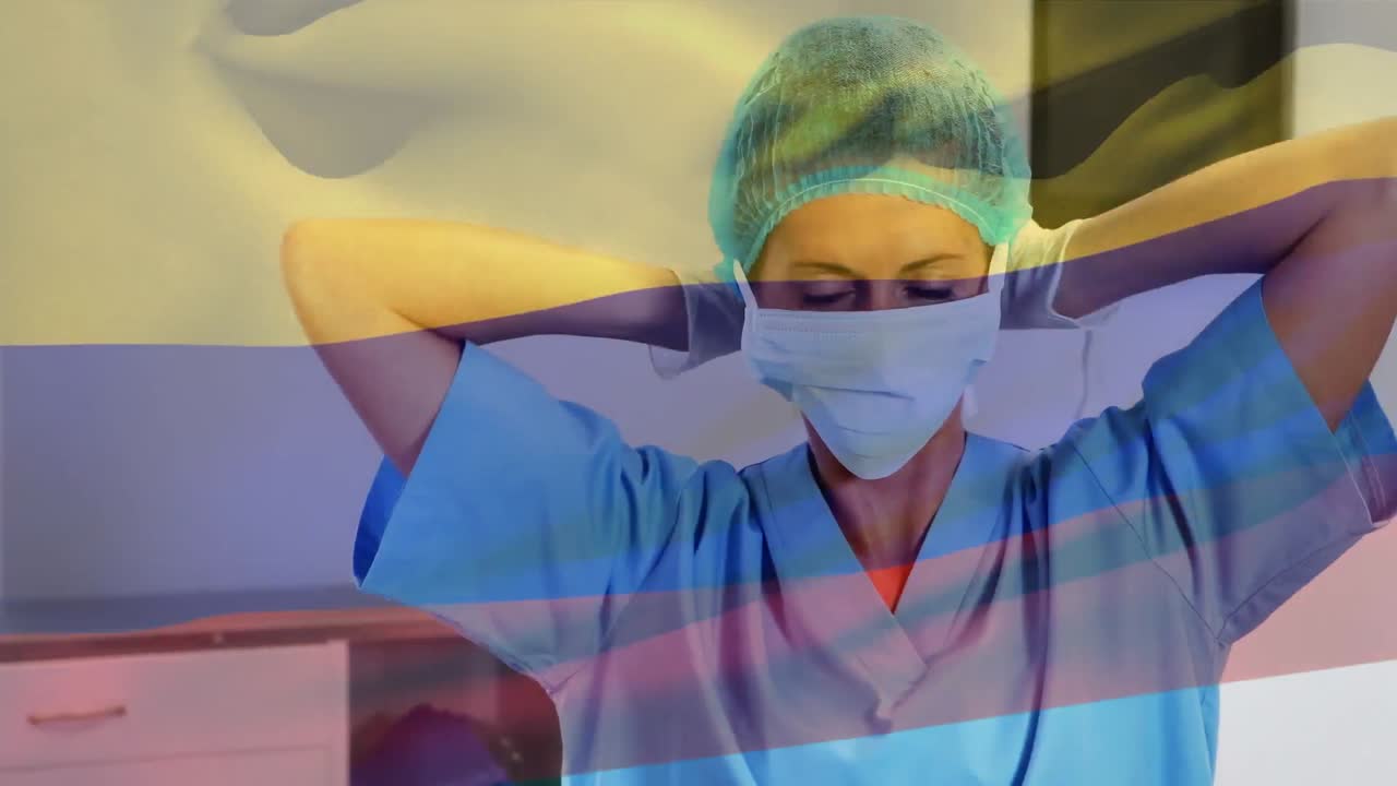 Animation of flag of cameroon waving over female surgeon in operating theatre