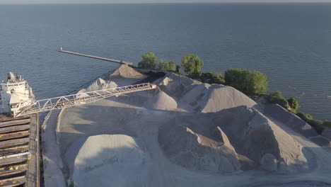 a large gravel slinger at work in a sand quarrying plant by the sea in kingsville, ontario, canada - aerial