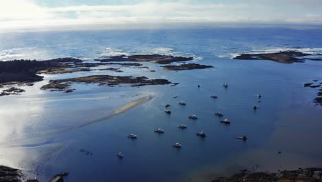 pullback to reveal a breathtaking view of the coast with a harbour full of lobster boats as the waves hit the many islands pocketing the area