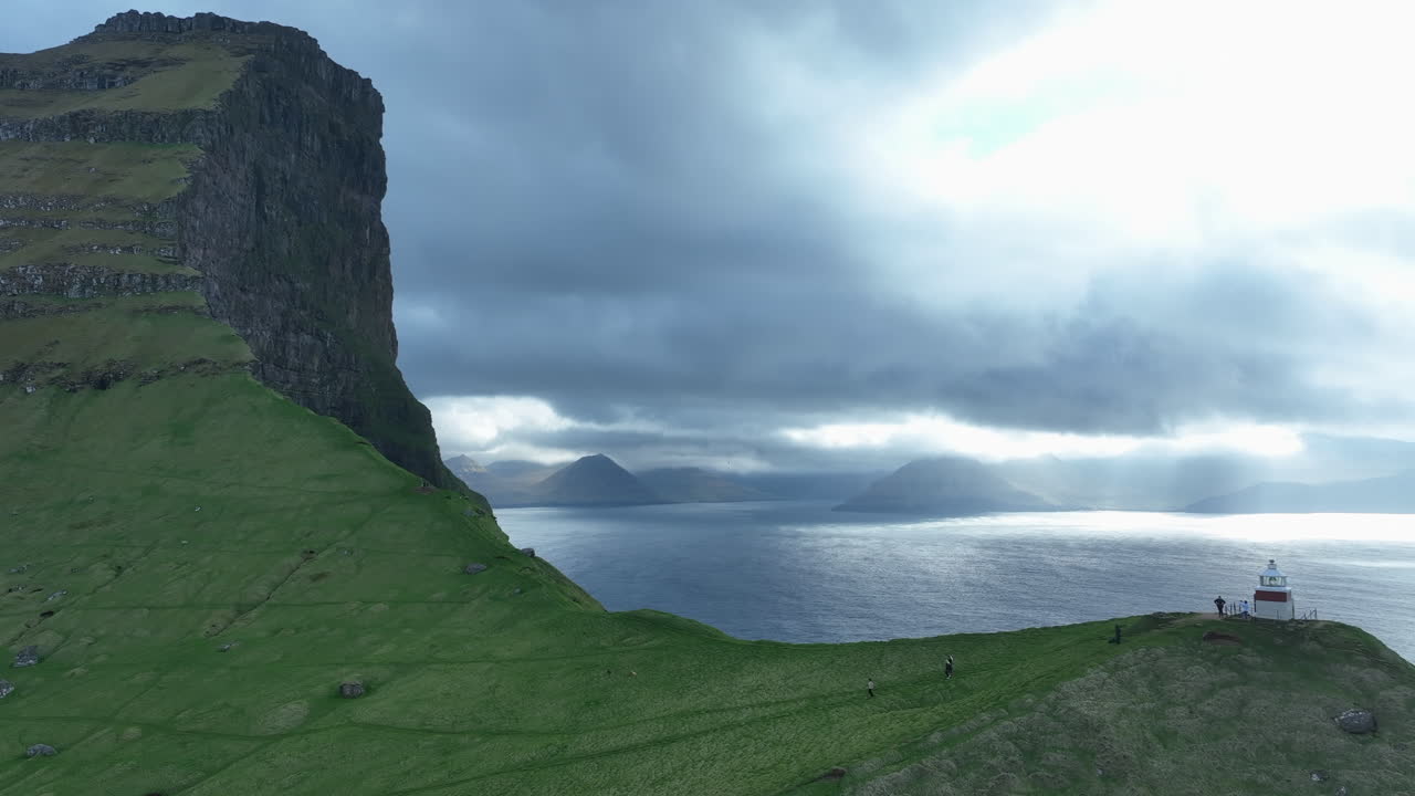 Aerial view of the famous Kallur Lighthouse on Kalsoy island with dramatic sun rays