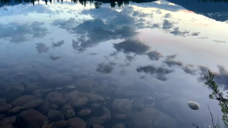 Cámara-Lenta-Que-Se-Inclina-Hacia-Arriba-Y-Revela-Un-Hermoso-Lago-Que-Refleja-El-Cielo.-