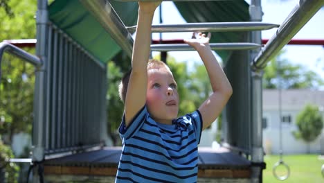 slow motion shot of a young boy playing on the monkey bars on a playground set in his backyard-1