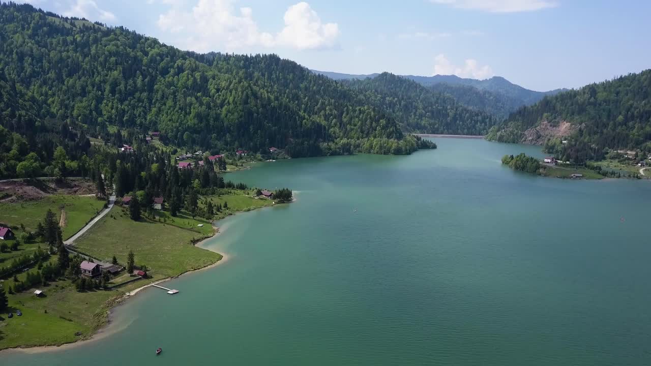 계곡의 배경에 맑은 물과 나무가 있는 호수의 공중 느린 패닝 샷