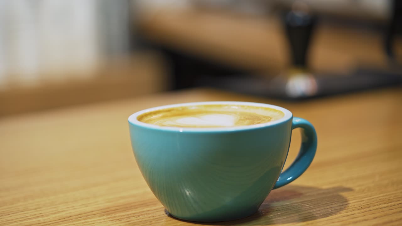 Cup of coffee on wooden table. Barista selling coffee to consumer in cafe