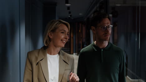 Business colleagues walking and discussing in an office hallway