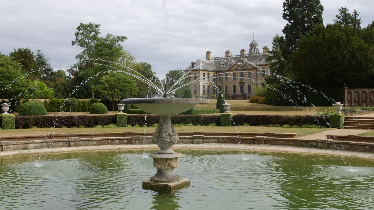 영국의 부유한 매너 하우스의 호화로운 정원에 있는 대형 수영장의 분수대