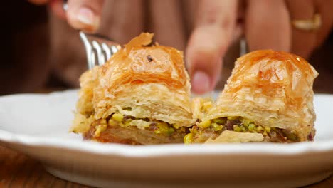 a plate of baklava being eaten with a fork and knife