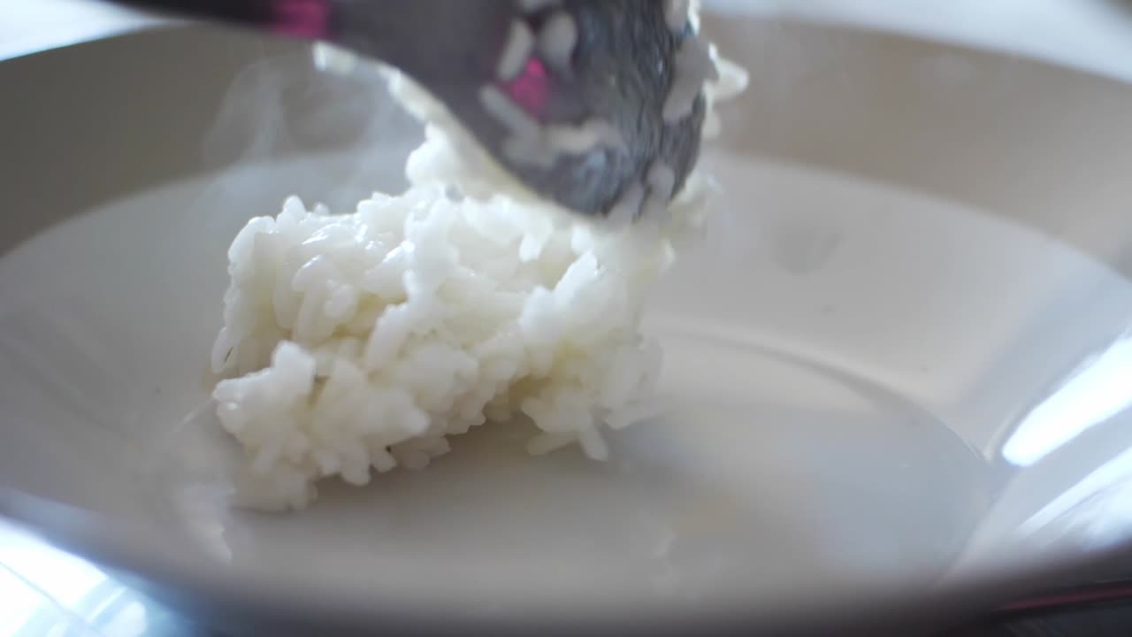 colocando arroz blanco al vapor en un plato
