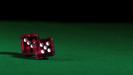 pink dice falling and bouncing on green table