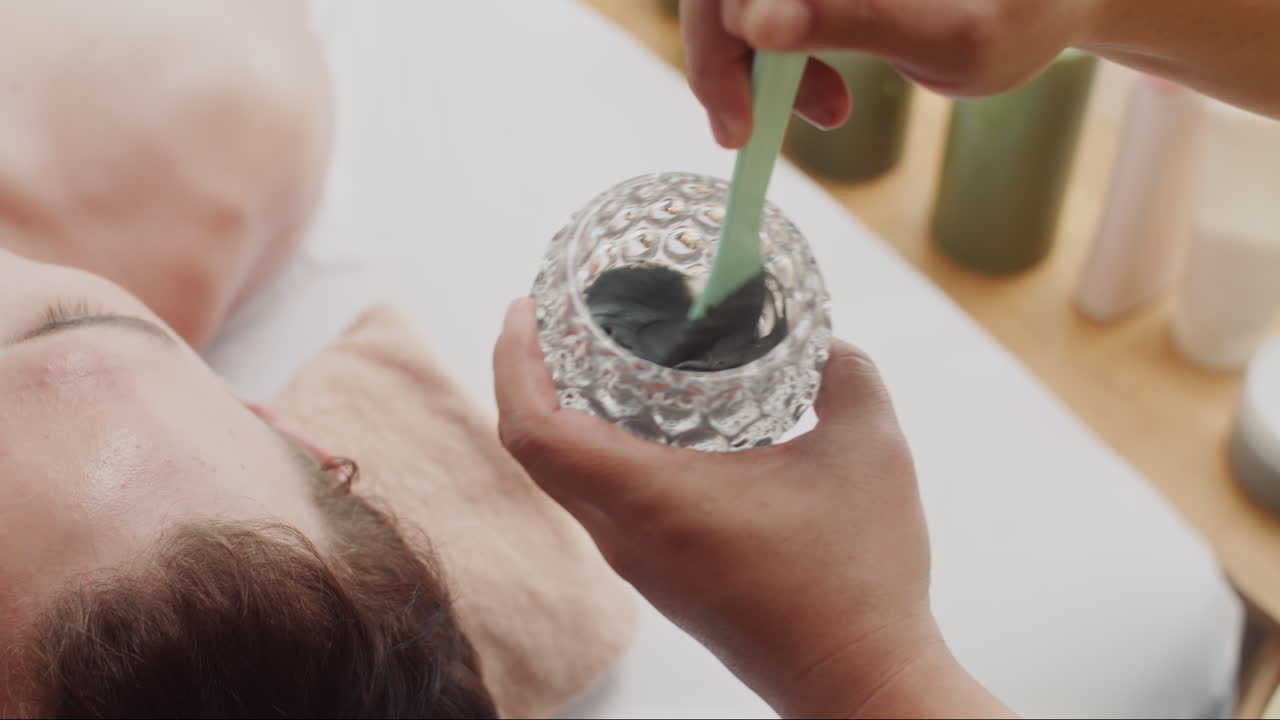 Beauty Specialist Mixing Clay before Applying to Skin