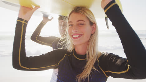 Pareja-Caucásica-Sosteniendo-Tablas-De-Surf-En-La-Playa