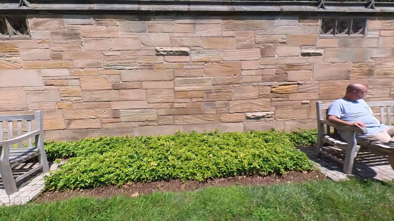 팬 4k 왼쪽에서 오른쪽으로 벤치에 앉아 있는 남자