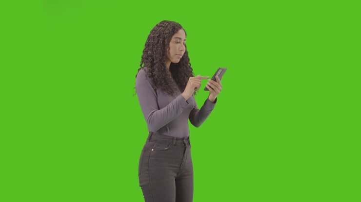 Donna che guarda il telefono cellulare e festeggia una buona notizia su sfondo verde 5.