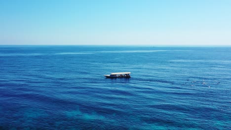 tourists-snorkeling-in-the-open-sea-near-the-tour-boat