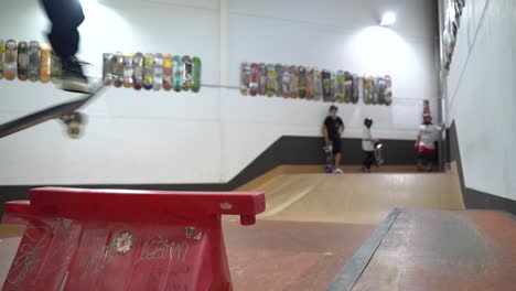 slow motion shot of caucasian man jumping over obstacle with skateboard.indoor skatepark during covid-19 time.