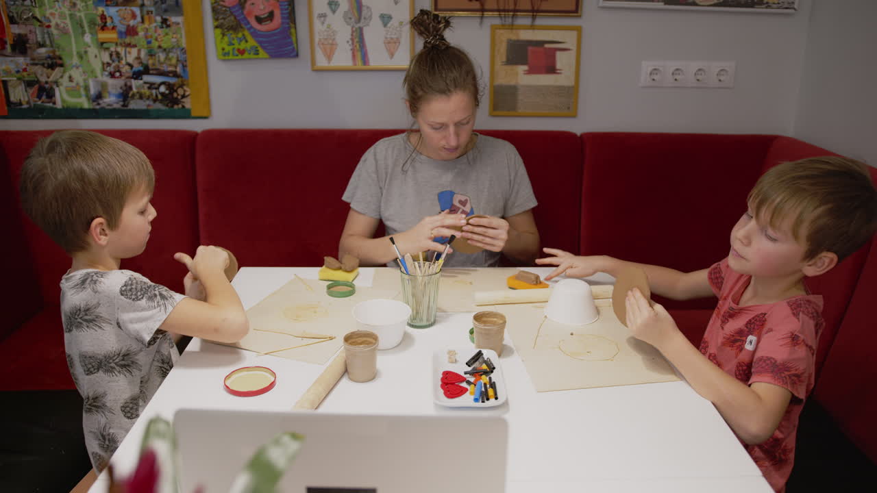 Family during Remote Online Clay Workshop. Twin boys and mother working with clay at home.