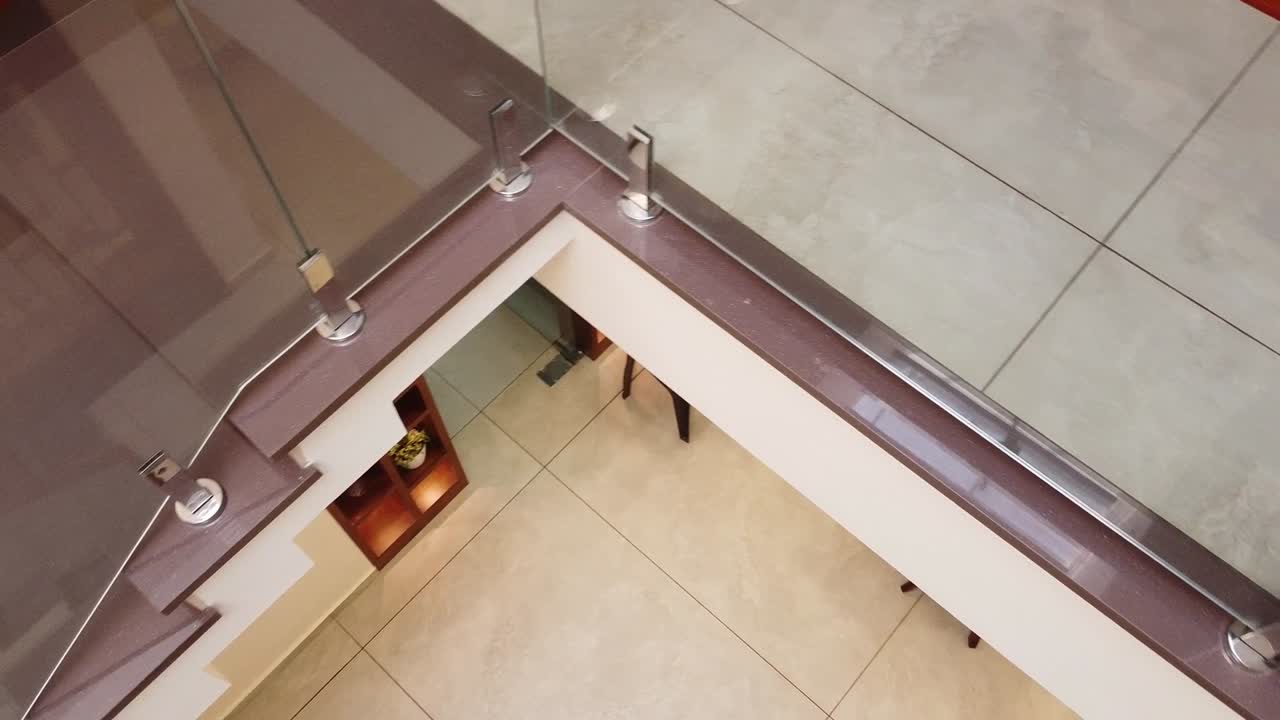 Modern Kerala home interior staircase with wooden handrail, glass railing, and stylish design. Elegant Indian house architecture with natural light, minimal decor, and contemporary lifestyle space