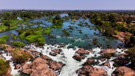 aerial view of mekong river rapids near don det, laos, water splitting through rugged rocks and green islets within the si phan don floodplain, where seasonal flows shape the braided river landscape