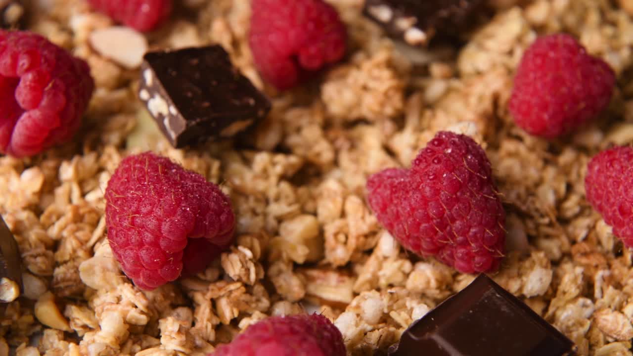 Detail close up shot of granola with chocolate and raspberries
