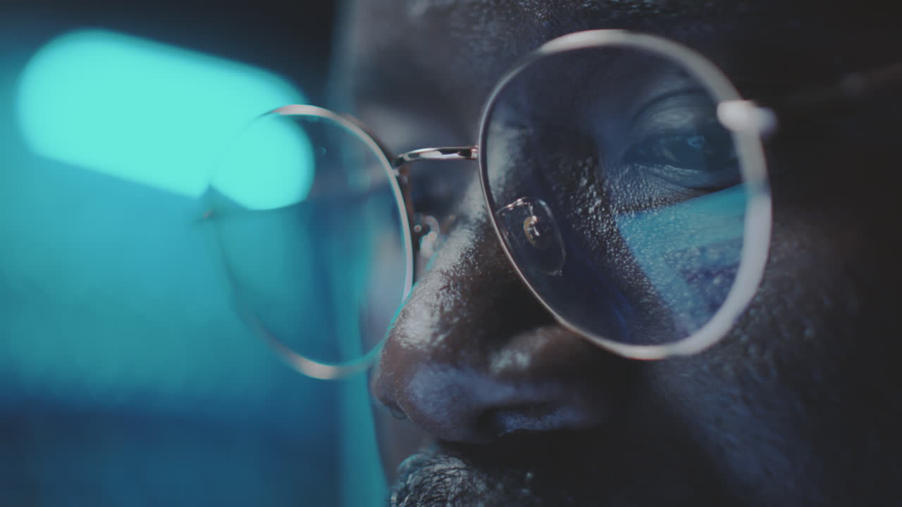 Close-up of a person wearing glasses with blue light reflection