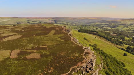 Aerial-shot-over-a-beautiful-green-countryside-hill-and-fields-in-England