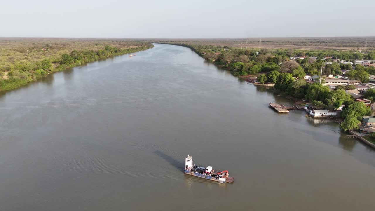 Traditional boats on the Gambia River seen from above, with water reflections at sunset creating a serene atmosphere