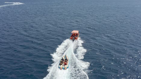 gente en un barco de plátano y un barco de velocidad en el océano