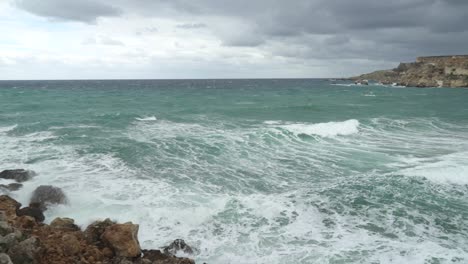 mar mediterráneo de color azul lavando la orilla de la bahía de playa dorada en malta