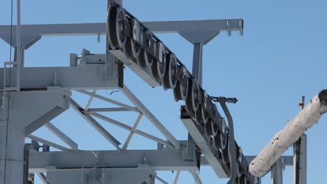 cable car wheels atop of a tower with blue sky background, close up