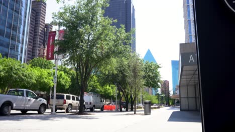 clean dallas street with office buildings, parked cars, and trees