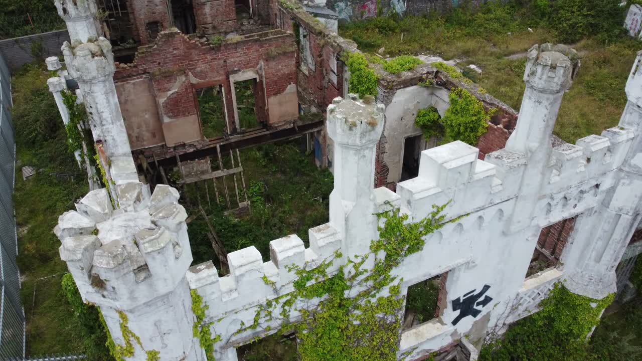 Soldiers point house aerial view over abandoned ruins of white castle mansion Holyhead country park