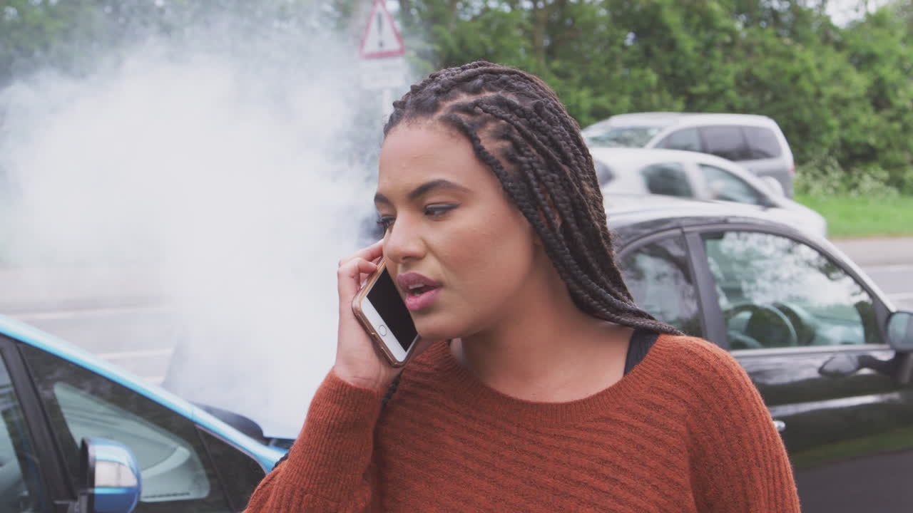 mujer conductor involucrada en un accidente automovilístico llamando a la compañía de seguros desde la carretera