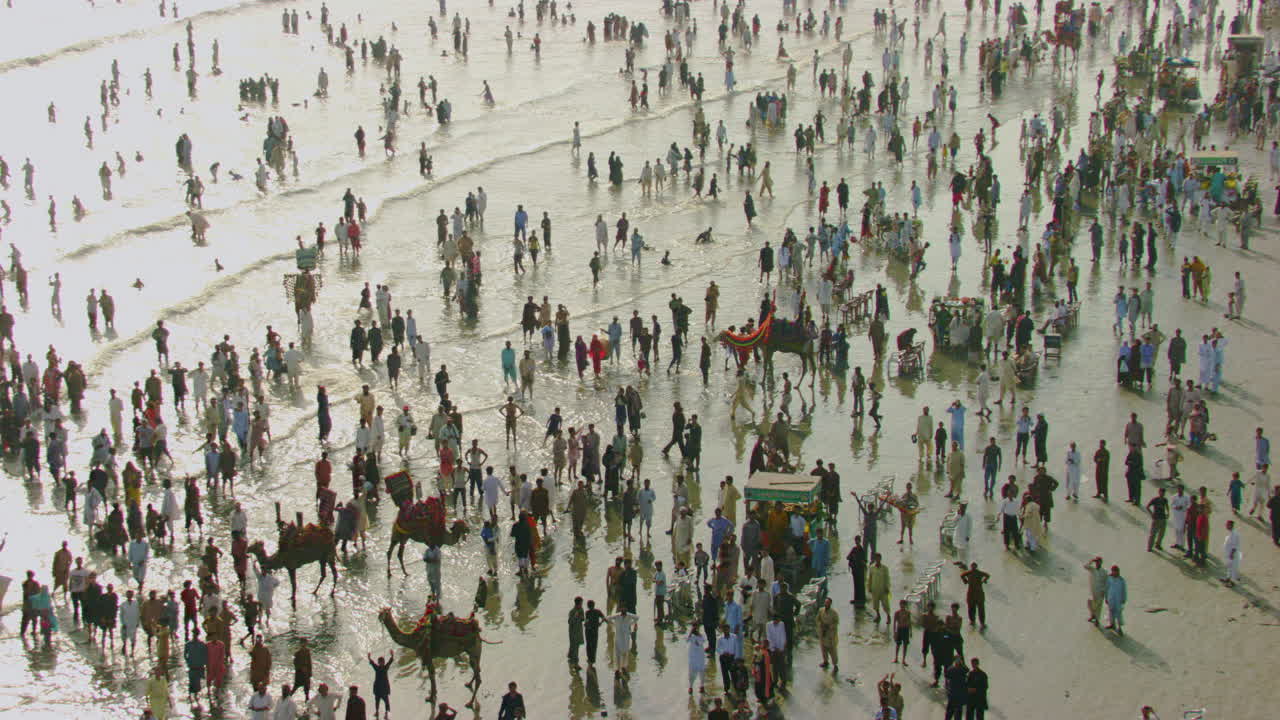 vista aérea de la playa con vista al mar en karachi, pakistán, cientos de personas están juntas para disfrutar, hermosos rayos de sol en las olas del mar