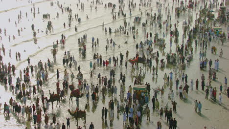 aerial view over the sea view beach at karachi pakistan, hundreds of people are together to enjoy, beautiful sun rays on the waves of sea