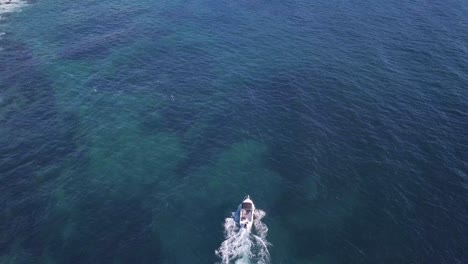 top down overhead view over a fishing boat above the ocean surface at the sydney beach