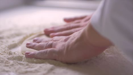 chef preparing dough for pizza on table