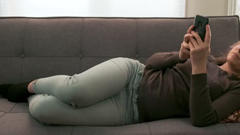slider shot of a young blonde woman browsing through her cellphone