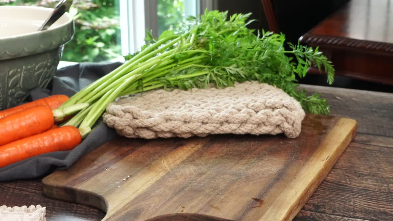 Using a knife to slice and chop a big yellow or Spanish onion on a wooden cutting board. Making Italian Wedding Soup and close up slice of the onion. Making dinner in the kitchen.