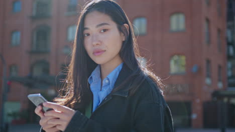 portrait of beautiful asian woman with smartphone on the street
