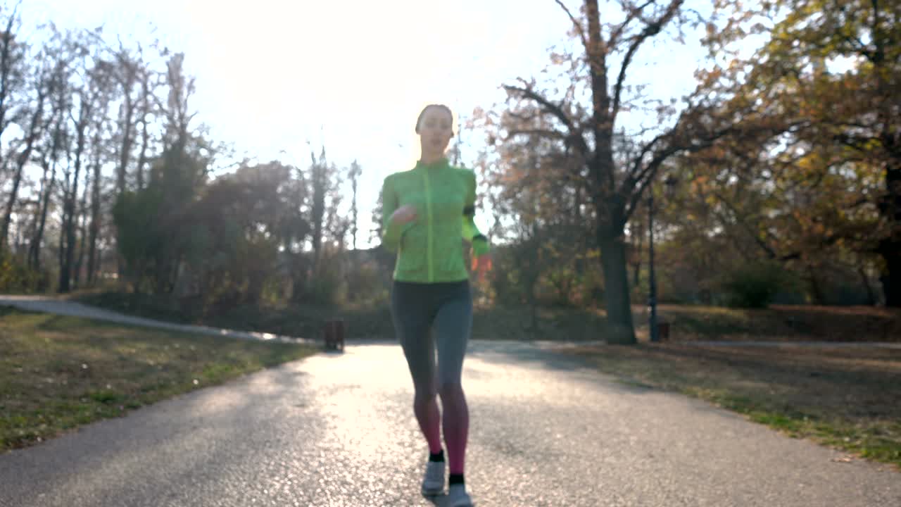 Woman running in the park and coming towards the camera