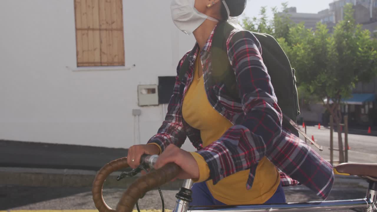 거리에서 의료 코로나바이러스 마스크를 착용한 여자가 자전거  ⁇ 에서  ⁇ 고 있다