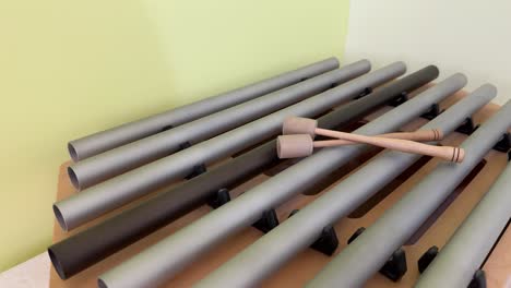 a pair of wooden mallets resting on a harmonized xylophone, used in sound therapy - close up
