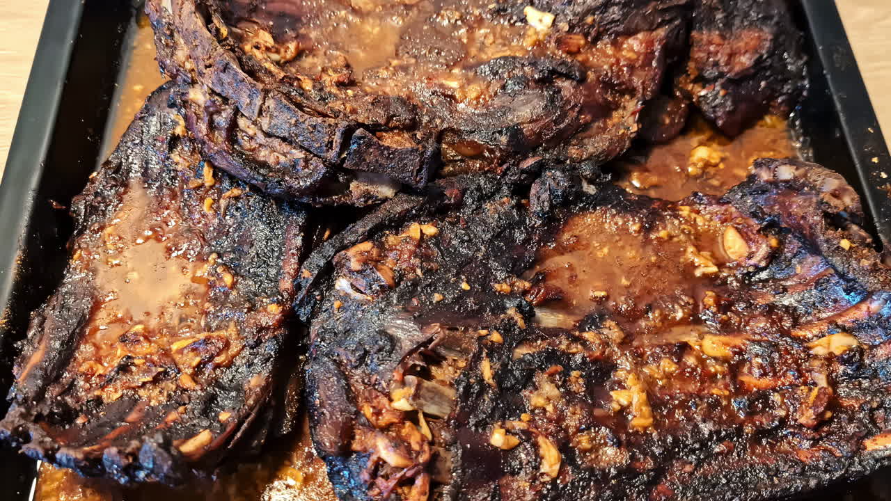 Cooked meat with slightly burnt, blackened edges from staying in the oven too long.